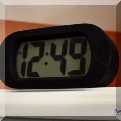 D44. Small black oval digital clock. - $6
